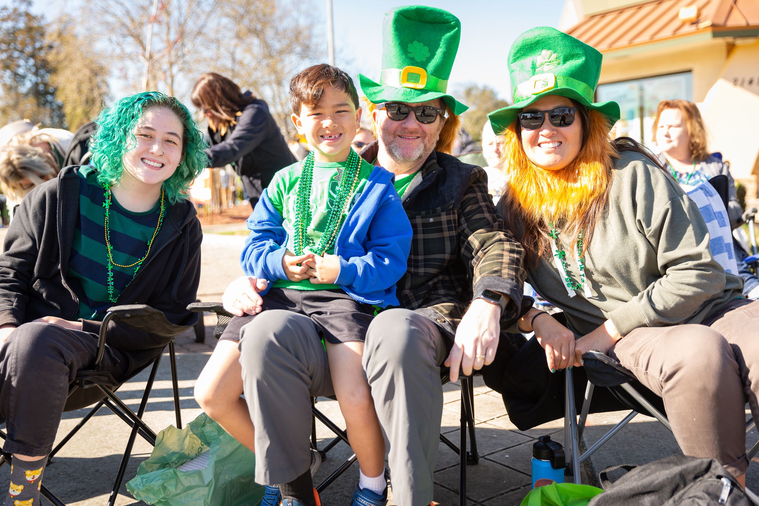 A family, all dressed in green, waits for the St. Patrick's Day Parade.