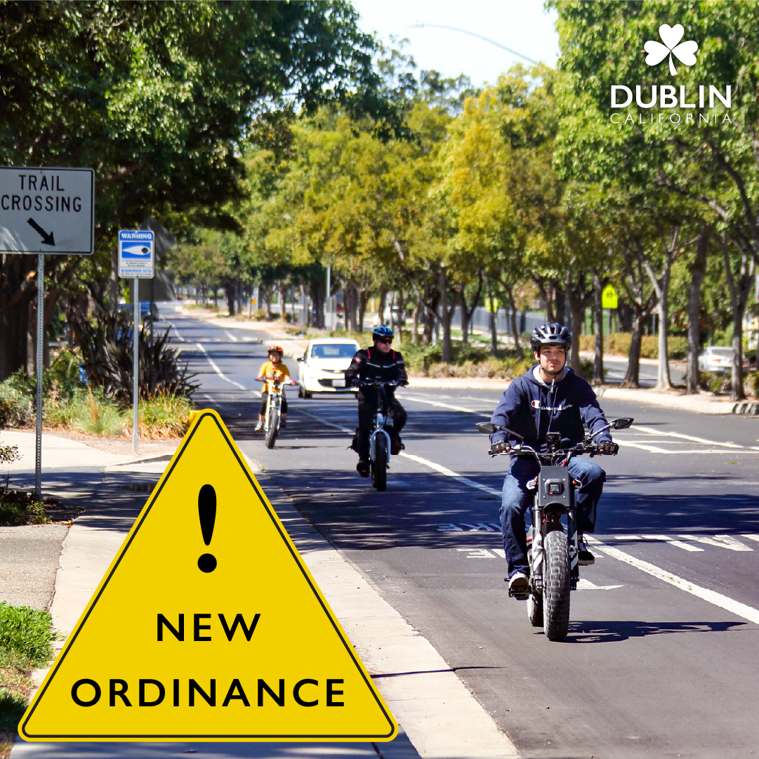 Three people ride their e-bikes in the bike lane on a street in Dublin. 